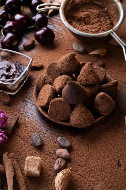 Sağlıklı ve lezzetli mantarlı sanat arkaplanı, çikolata ve besleyici maddeler: doğal kakao çekirdekleri, toz, çikolata, badem fıstığı ve olgun kiraz. sağlıklı tatlı konsepti. 