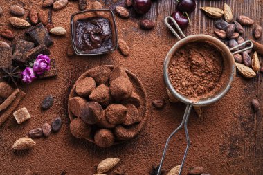 Sağlıklı ve lezzetli mantarlı sanat arkaplanı, çikolata ve besleyici maddeler: doğal kakao çekirdekleri, toz, çikolata, badem fıstığı ve olgun kiraz. Sağlıklı tatlı konsepti. düz yat
