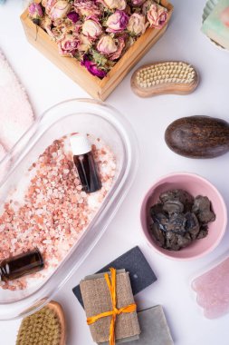 Beyaz arka planda tuz, şifalı çamur ve sabun bulunan doğal spa seti. Derisi yüzülmüş