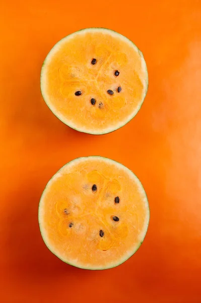 Połowa Świeżego Dojrzałego Arbuza Pomarańczowego Wokół Pomarańczowego Tła — Zdjęcie stockowe