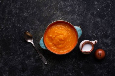 Ahşap siyah masada sunulan hindistan cevizi sütlü fırında balkabağı kreması. Düz yat. yemek ve sağlıklı yaşam konsepti