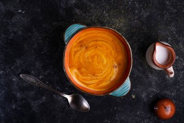 Ahşap siyah masada sunulan hindistan cevizi sütlü fırında balkabağı kreması. Düz yat. yemek ve sağlıklı yaşam konsepti
