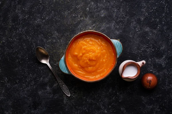 Ahşap siyah masada sunulan hindistan cevizi sütlü fırında balkabağı kreması. Düz yat. yemek ve sağlıklı yaşam konsepti