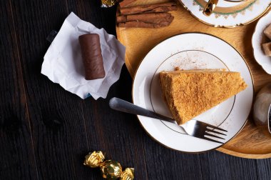 Siyah ahşap masadaki ahşap tepside tatlı ile servis edilen kahve. düz yat