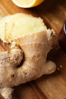 Tahta masada limonla taze zencefil doğramak. Sağlıklı konsept