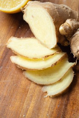 Ahşap masada taze zencefil baharatı kesiyor. Sağlıklı konsept