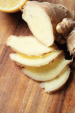 Ahşap masada taze zencefil baharatı kesiyor. Sağlıklı konsept