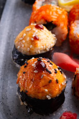 Siyah masadaki gri tepside suşi hazır. Düz yat. Kapat.