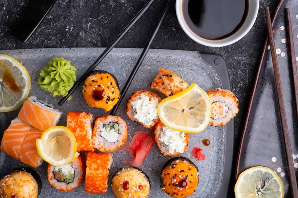 Sushi Rolset Geserveerd Grijze Schaal Aan Zwarte Tafel Vlakke Wip — Stockfoto