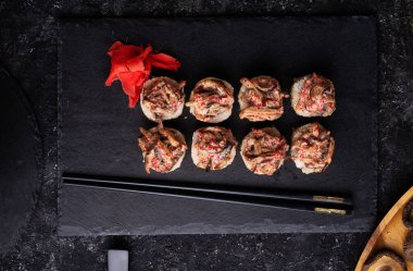 Siyah masada servis edilen siyah tabakta Shiitake mantarlı suşi rulosu. düz yat