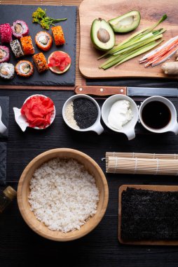 Siyah masada servis edilen siyah tabakta pilav ve malzemelerle birlikte suşi pişirme seti. düz yat