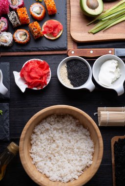 Siyah masada servis edilen siyah tabakta pilav ve malzemelerle birlikte suşi pişirme seti. düz yat