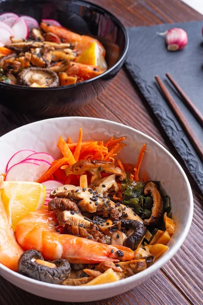 Midye, karides, şitake mantarı ve sebzeli miso çorbası. Koyu kahverengi ahşap masada servis ediliyor. düz yat