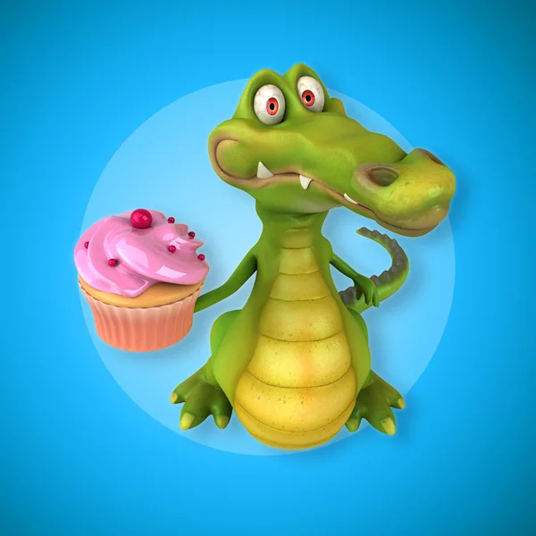 Crocodile holding cupcake — стоковое фото