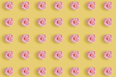 Buruşmuş pembe masa peçetesi sarı arka planda tekrarlanıyor. Asgari tasarım konsepti