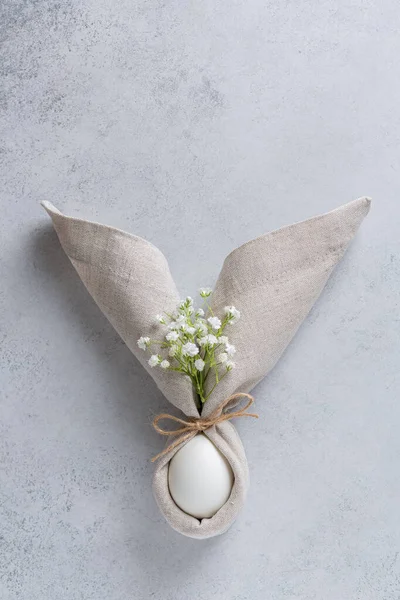 Paskalya masa süslemesi, peçeteli yumurta ve küçük beyaz çiçekli kulaklı Paskalya tavşanı şeklinde. Paskalya masa süslemeleri. Üst görünüm, alanı kopyala 