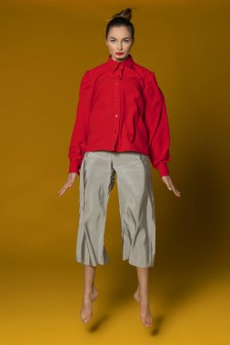 Sarı arka planda kırmızı ve gri elbiseli çekici moda kızı saç stili, konsept güzellik. 