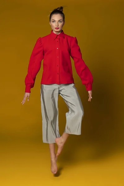 Prachtig Model Met Rood Shirt Grijze Broek Springen Gele Achtergrond — Stockfoto