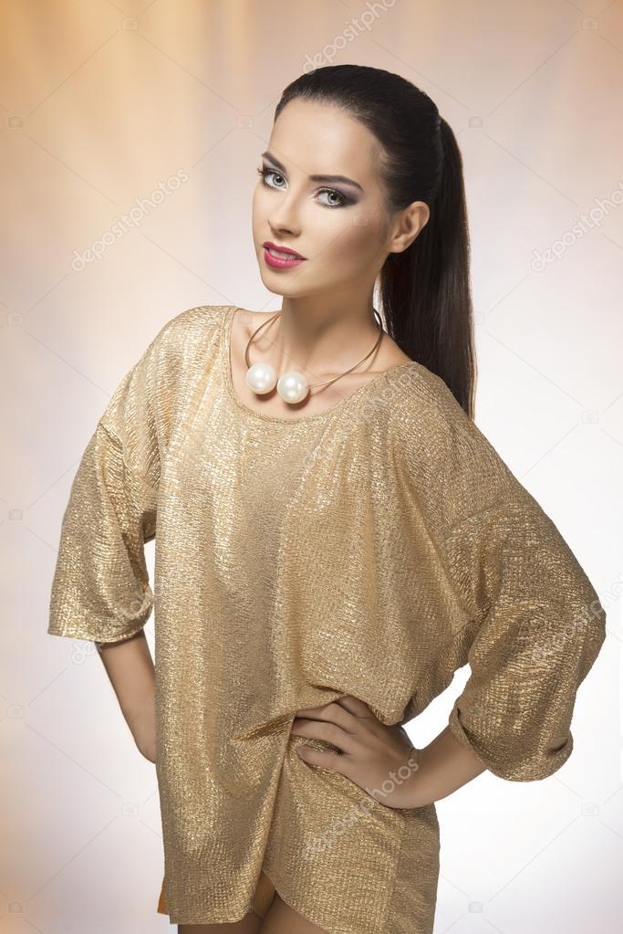 Young woman in spakling gold dress