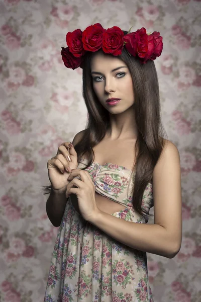 Linda menina com rosas na cabeça — Fotografia de Stock