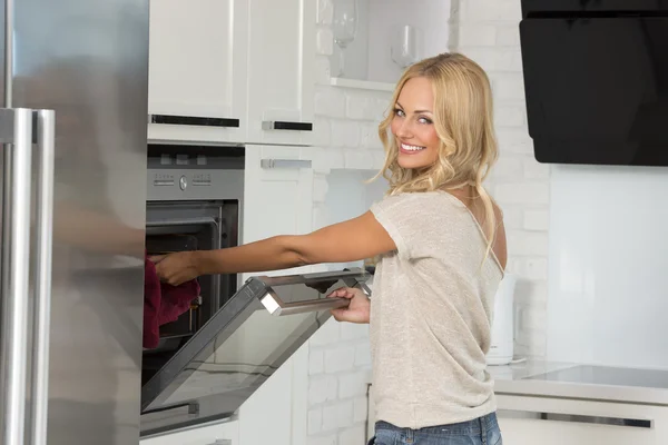 Gadis memasak dengan oven dengan senyum besar — Stok Foto