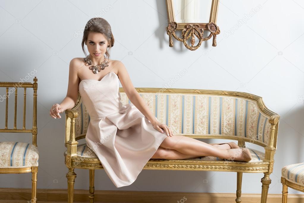 elegant girl lying on vintage sofa 