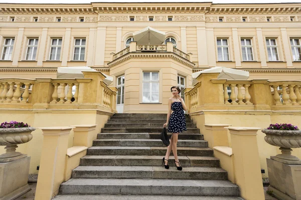 Rich girl in blue near a big palace — Stock Photo, Image