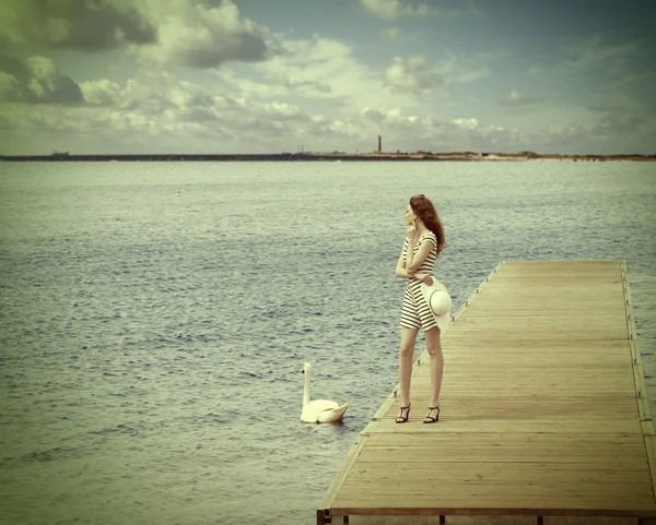 Chica en el muelle con cisne. color vintage — Foto de Stock