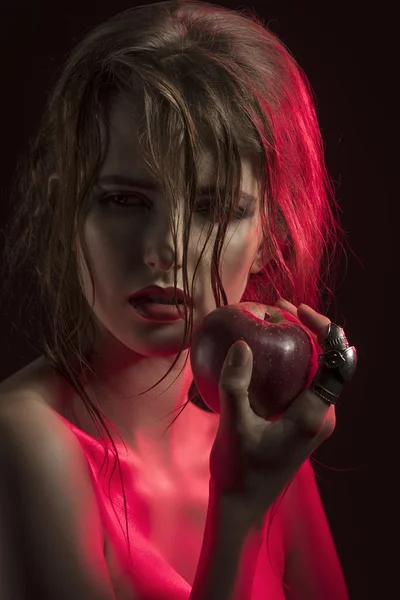 Сексуальная девушка в полусвете с яблоком — стоковое фото