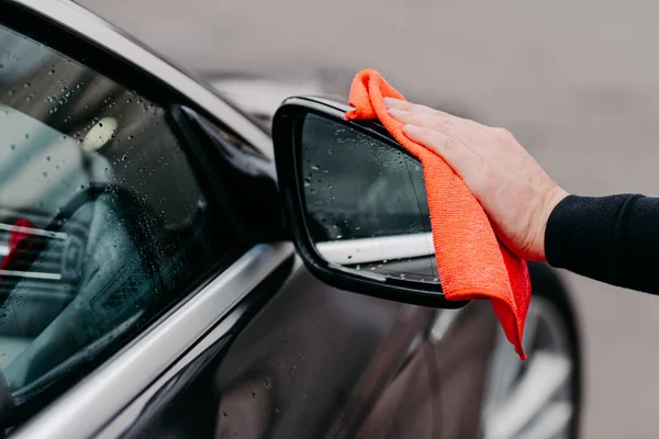 Detailní Záběr Člověka Rukou Otírající Vodu Černé Auto Mikrovláknitou Látkou — Stock fotografie