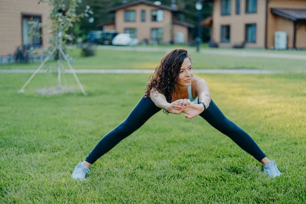 Femme Sportive Confiante Démontre Flexibilité Étend Extérieur Fait Des Exercices — Photo