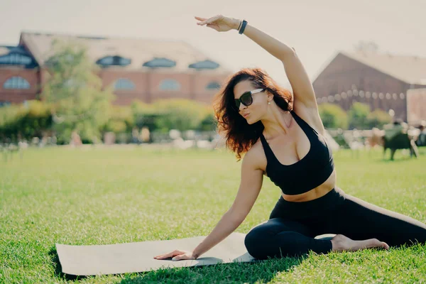 Image Motivated Fit Woman Raises Arm Does Stretching Exercises Outdoors — Stock Photo, Image