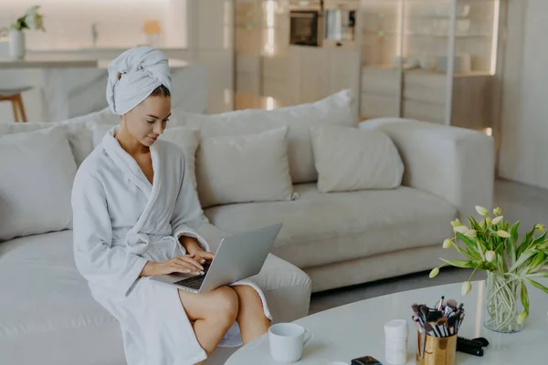 Photo Beautiful Young Woman Bathrobe Types Laptop Computer Works Distantly — Stock Photo, Image
