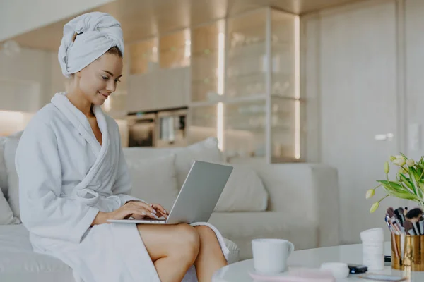 Horizontal Shot Satisfied Beautiful Woman Dressed White Soft Bathrobe Works — Stock Photo, Image