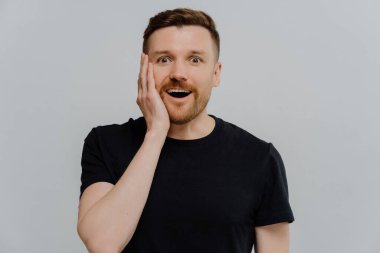 Şok olmuş mutlu ifadeyle kameraya bakan şaşkın kızıl adam.