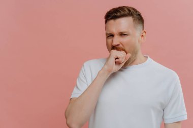 Genç sıkılmış adam esniyor ve ağzını yumrukla açıyor.