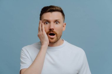 Şok olmuş bir adam şaşırmış bir ifadeyle kameraya bakıyor.