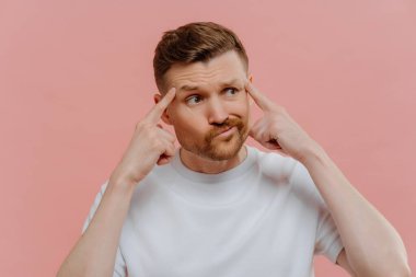 Genç adam bir şey düşünüyor ve parmaklarını şakaklarına koyuyor.