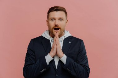 Şaşırmış bir adam dua ediyor ve iyi şanslar diliyor.