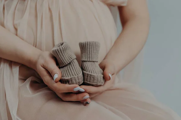 출산 과 임신이라는 개념입니다. 출산을 앞두고 있는 임신부는 손에 부츠를 들고 3 개월째 실내에 있게 된다 — 스톡 사진