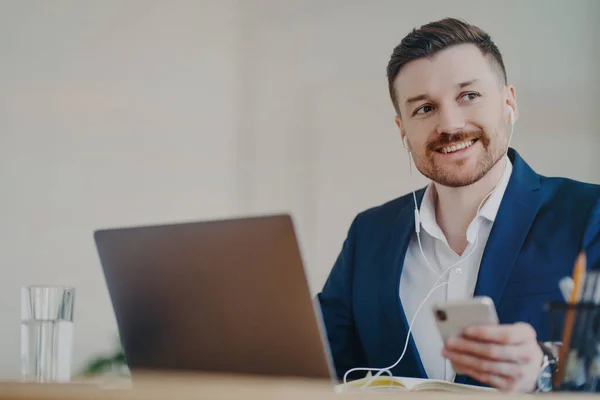 Joven empresario sonriente que participa en videoconferencia con auriculares — Foto de Stock