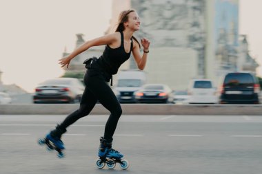 Genç, koyu renk saçlı, zayıf, sağlıklı bir kadın hız yaparken paten kaymaktan zevk alır. Neşeli bir ifadesi vardır. Siyah tişört ve tayt giyer. Aktif dinlenme ve spor eğitimi konsepti