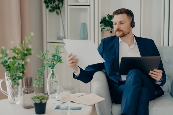 Aattentive male employee looking at documents in his hand — Photo