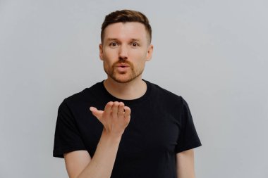 Genç adam kız arkadaşına hava öpücüğü veriyor ve duygularını gösteriyor.