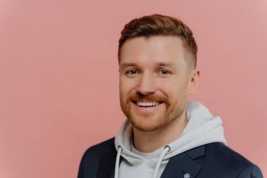 Pembe arka planda neşeli, yakışıklı bir adam.