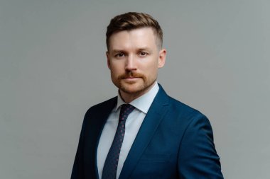 Ciddi özgüvenli erkek patron ya da iş adamı kameraya özenle bakıyor.