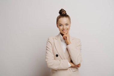 Profesyonel çekici iş kadını elini çenesinin altında tutuyor.