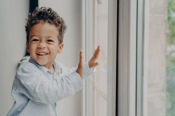 Портрет маленького радісного чорношкірого хлопчика з чарівною посмішкою розважається вдома — стокове фото