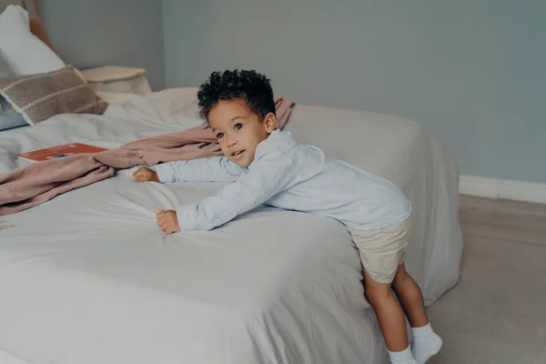 Dulce niño afroamericano pequeño jugando en el acogedor dormitorio en casa — Foto de Stock