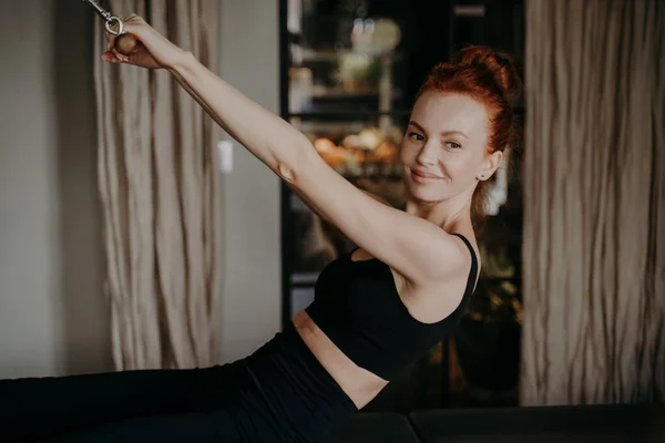 Ginger muda tersenyum sambil melakukan latihan pada pembaharu pilates — Stok Foto